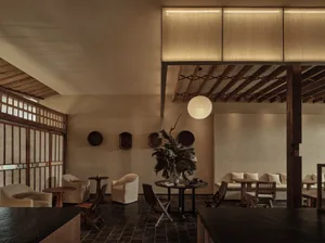 A well-lit modern living space with a dining table, chairs, couches, and a decorative vase, surrounded by a modern design