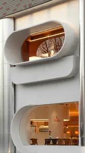 Interior view of a contemporary office space with a metal spiral staircase, concrete walls, and a sense of practicality and efficiency