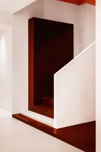 Cozy interior staircase with wooden steps and a brown tint, creating a sense of depth with two sets of steps
