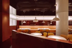 Warm and inviting restaurant interior with wooden tables and chairs, well-designed lighting, and a cozy atmosphere