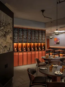 Warm and inviting restaurant interior with wooden tables and chairs, wine bottles, and a comfortable atmosphere