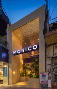 夜晚現代店面，大片窗戶展示三株盆栽，營造當代都市的溫馨氛圍