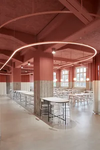 Bright and inviting restaurant interior with pink walls, white stools, and natural light from windows