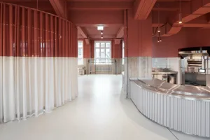Industrial kitchen with a stainless steel counter, dining table, and two sinks, suggesting a modern and functional design