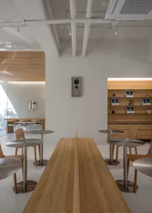 Open modern kitchen and dining space with wooden floors and walls, featuring a dining table, chairs, and kitchen appliances, with various decorative items and a lived-in feel