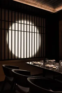 Elegant dining space with a wooden table and chairs, wine glasses, and a sophisticated atmosphere