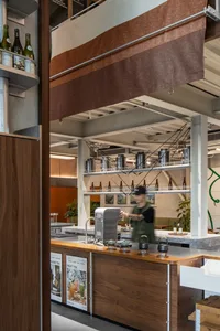 休閒餐廳內部，櫃檯上陳列各式物品、瓶裝飲料，並有服務人員招呼顧客