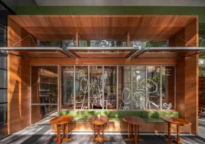 Warm and inviting restaurant interior with wooden floors and walls, featuring tables and chairs for guests