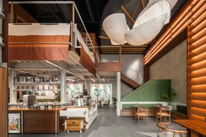 Open modern kitchen and dining space with a wooden island, potted plants, and a warm atmosphere