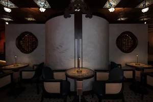 Modern restaurant dining space with wooden and metal elements, warm lighting from lamps, and a minimalist atmosphere