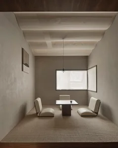 Dimly lit living area with a dining table and chairs, minimalistic design, and a cozy seating arrangement