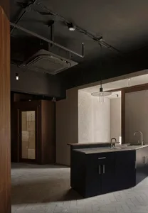 Empty kitchen with cement block walls, a sink, countertop, and cabinets, with a bottle on the counter