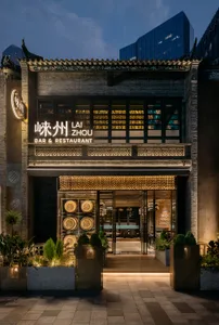 A modern Asian restaurant with a spacious interior, bar area, and potted plants, creating a welcoming atmosphere