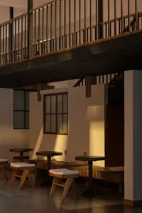 Warm and inviting restaurant interior with wooden tables and chairs, creating a comfortable atmosphere for dining and conversation