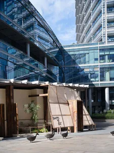 A modern building with a large glass window and two benches in front, set in a calm and inviting daytime scene