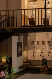 A museum-style interior with artworks on the walls and sculptures throughout, creating a space for art appreciation