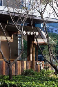 A modern Asian restaurant with wooden elements, natural light, and a warm ambiance, featuring a dining area with chairs and potted plants
