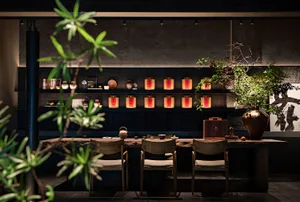 Cozy Asian restaurant interior with wooden tables, chairs, and decorative items, featuring potted plants and cultural influences