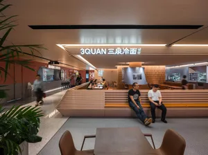 Casual restaurant interior with wooden benches and tables, people sitting and standing, warm atmosphere