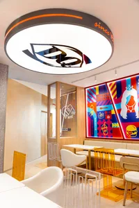 Warm and inviting restaurant interior with wooden walls and floors, featuring comfortable seating areas with chairs and dining tables