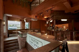 Inviting cafe with a counter area, chairs, and dining tables, well-lit with natural and artificial light