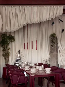 A dining area with a long wooden table set for a meal, surrounded by chairs, in a cozy and inviting atmosphere
