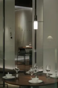 A dining area with a wooden table and chairs, wine glasses, and utensils, set in an elegant and inviting atmosphere