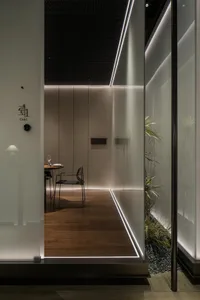 Elegant dining room with a wooden dining table and chairs, a potted plant, and a wine glass on the table, creating a warm and inviting atmosphere