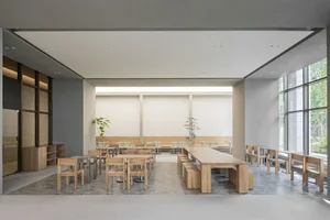 Empty restaurant with wooden tables and chairs, clean and well-organized space with a warm ambiance