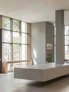 Open modern living area with natural light, chairs, and multiple dining tables