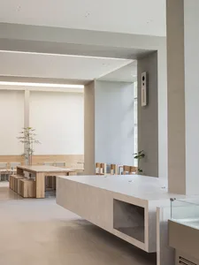 Empty room with a central countertop, chairs, and a dining table, exuding a calm and inviting atmosphere with a focus on functionality and comfort