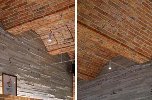 Warm and inviting interior space with exposed brick walls, modern wood and metal elements, and a mix of rustic and modern design