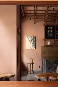 A living area with a dining table, chairs, and a fireplace, surrounded by wood walls, creating a warm and inviting atmosphere