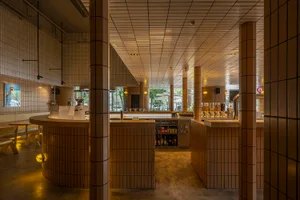 Modern restaurant interior with a bar area, dining chairs, and a focus on functionality and aesthetics
