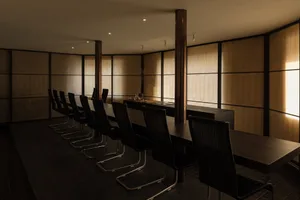 A warm and inviting restaurant dining area with a wooden table surrounded by chairs, creating a comfortable space for guests to enjoy their meals