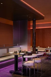A restaurant interior with wooden walls and tables, featuring comfortable seating and decorative items