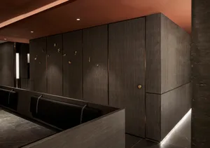 A warm and inviting room with wooden walls and floors, featuring two couches and three benches for ample seating