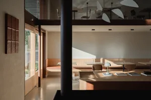 Modern dining space with a dining table, chairs, and a kitchen area, featuring a cozy atmosphere and comfortable seating