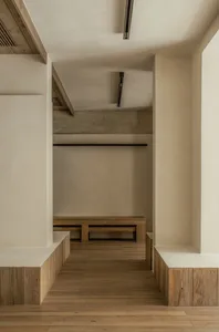 Empty lobby with wooden floors and walls, featuring two benches and a calm, inviting atmosphere