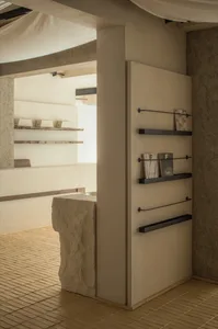 Interior room with stone walls, a doorway, and two bookshelves with books and a decorative vase