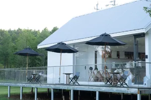 An outdoor dining area with several tables and chairs under umbrellas, creating a relaxed and inviting atmosphere