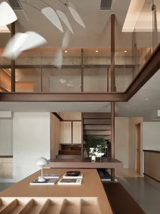 Open living area with wooden floors and walls, featuring two potted plants and a vase, in a modern and contemporary style