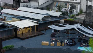 Casual outdoor dining area with tables, chairs, and umbrellas, surrounded by a comfortable atmosphere for guests to enjoy meals
