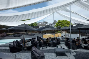 A patio seating area with black chairs and umbrellas, arranged for comfortable relaxation and shade