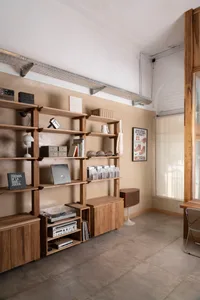 A cozy interior design showroom with a large wooden bookshelf and multiple chairs, filled with books and records