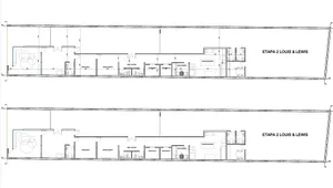 A large, open industrial space with white walls, no furniture, and a clean, bright appearance
