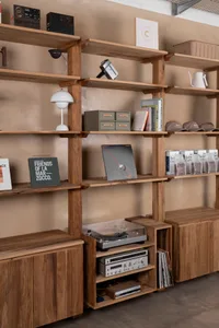 A well-organized bookshelf with books and a record player, creating a cozy atmosphere for reading and listening to music