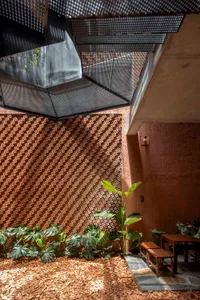 充滿各種盆栽植物、兩張長椅，燈光明亮且溫馨誘人的空間
