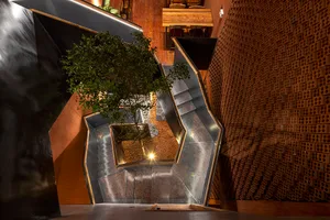 A modern building with multiple levels, stairs, and trees, featuring a well-designed and functional space