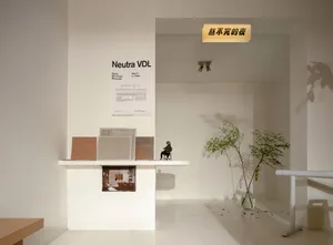 A modern showroom with two tables, chairs, and potted plants, creating a clean and inviting atmosphere